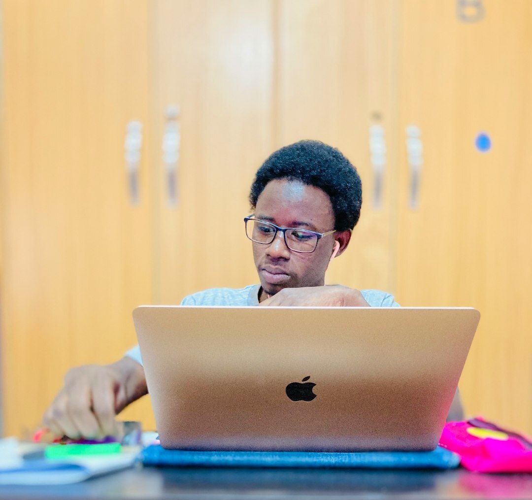 Portuguese male programmer coding on a laptop